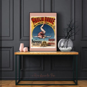 K&ouml;nnte beinhalten: Vintage-Plakat f&uuml;r das Moulin Rouge mit einer Frau, die einen Handstand auf einem Stapel Kanonenkugeln macht. Das Plakat ist in Franz&ouml;sisch und lautet "Moulin Rouge, Tous les Soirs a 9h, Avant le Bal, Petrescu, La merveille a 4 bras, Danse sur les Mains".