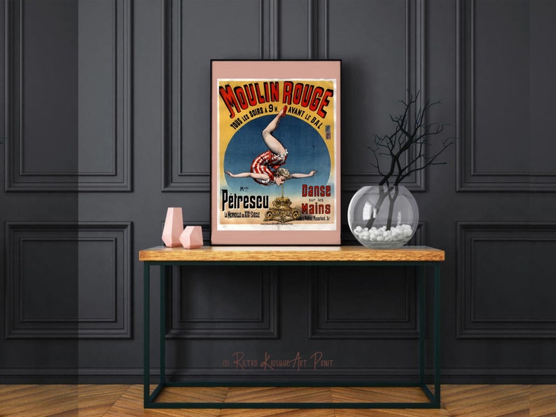 K&ouml;nnte beinhalten: Vintage-Plakat f&uuml;r das Moulin Rouge mit einer Frau, die einen Handstand auf einem Stapel Kanonenkugeln macht. Das Plakat ist in Franz&ouml;sisch und lautet "Moulin Rouge, Tous les Soirs a 9h, Avant le Bal, Petrescu, La merveille a 4 bras, Danse sur les Mains".
