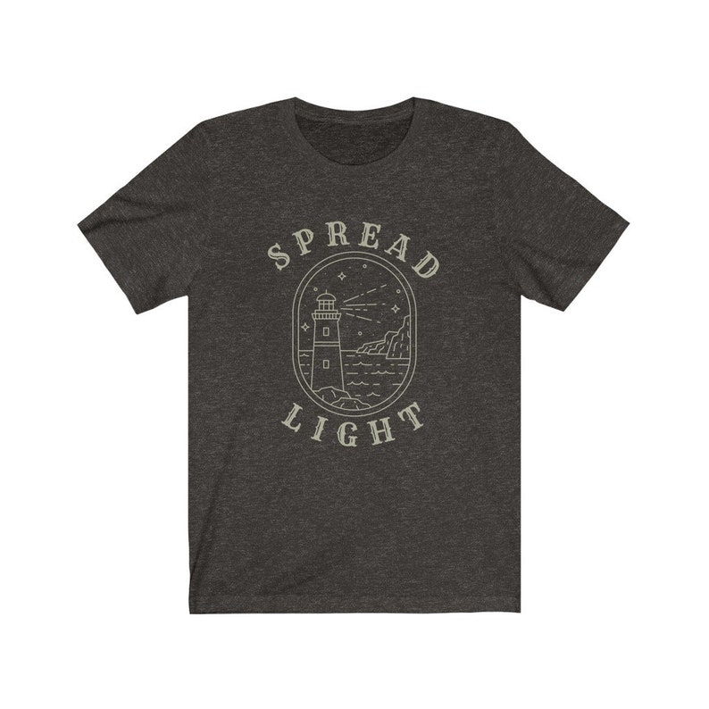 Op de afbeelding: Donkergrijs t-shirt met een vuurtoren afbeelding en de tekst "SPREAD LIGHT".