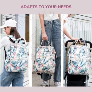 Peut inclure: Sac &agrave; dos &agrave; imprim&eacute; floral avec plusieurs poches et une poign&eacute;e sup&eacute;rieure. Le sac &agrave; dos pr&eacute;sente un fond cr&egrave;me avec des motifs floraux et de feuilles bleues et roses. Le texte "ADAPTS TO YOUR NEEDS" est en haut de l'image.