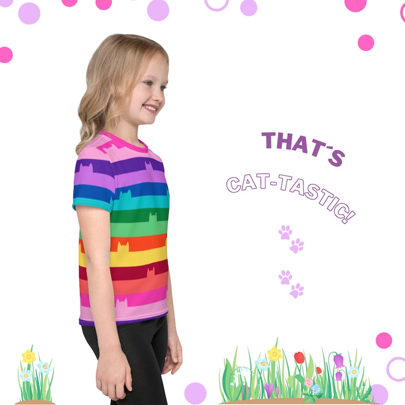 May include: A young person wearing a rainbow striped t-shirt with a cat silhouette pattern. The shirt has the text "THAT'S CAT-TASTIC!" on the right side of the image.