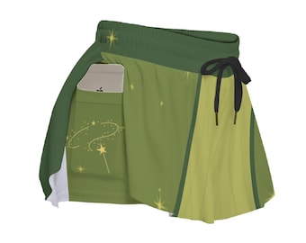 Puede incluir: Falda deportiva verde con bolsillo incorporado. La falda presenta un cordón, un forro blanco y un diseño de estrellas. La falda es una combinación de colores verde claro y oscuro.