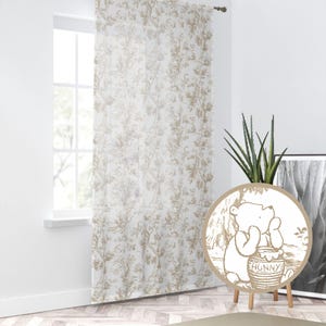 May include: A sheer white curtain with a beige floral pattern. The curtain is hanging in a window and there is a Winnie the Pooh character cutout in the foreground. The cutout is on a wooden stand and has the words "Hunny" on the pot of honey.