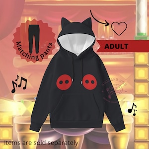 May include: Black adult hoodie with cat ears, red buttons, and the text "Hugs and Mugs Creative Designs by Telma".