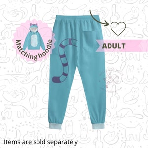 May include: Adult blue sweatpants with a purple and blue cat tail design on the left leg. The sweatpants have a pocket on the back right side. The text "HUGS AND MUGS CREATIVE DESIGNS BY TELMA" is printed on the right leg. The image also shows a matching blue hoodie with a cat face design.