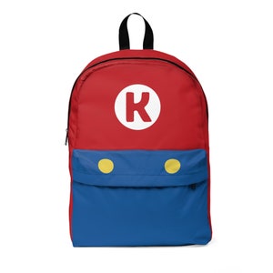 May include: Red and blue backpack with a white circle and the letter "K" in the centre. The backpack has two yellow circles on the bottom.
