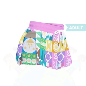 Könnte beinhalten: Ein bunter Rock mit pinkfarbenem Bund und weißem Kordelzug. Der Rock hat ein sich wiederholendes Muster aus geometrischen Formen, Zahlen und skurrilen Figuren in verschiedenen Farben. Das Wort "ADULT" ist auf der Seite aufgedruckt.