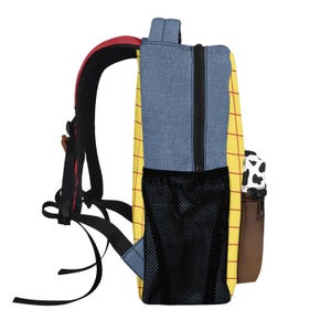 May include: A backpack featuring a yellow body with a red grid pattern, blue denim-like side panels, and a black mesh side pocket. The front pocket displays a black and white cow print above a solid brown base, with black adjustable shoulder straps.