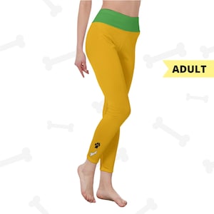 May include: Mustard yellow leggings with a green waistband. A black paw print and bone graphic is on the lower leg. The word "ADULT" is in a yellow banner.
