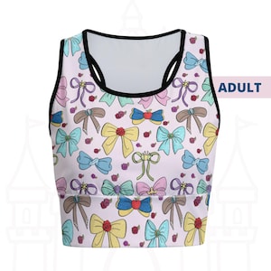 May include: A light pink sports bra with a black trim and a pattern of colorful bows and roses. The word "ADULT" is printed on the right side of the bra.