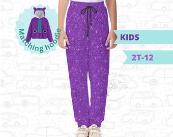 May include: Purple glitter sweatpants with a drawstring waist and elastic cuffs. The image also shows a matching purple hoodie with a cartoon face. Text on the image says "KIDS" and "2T-12". The text "Items are sold separately" is also visible.