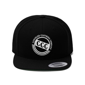 May include: Black and white flat brimmed baseball cap with a white logo that says "Canceled Clothing Company" with the letters CCC in a circle.