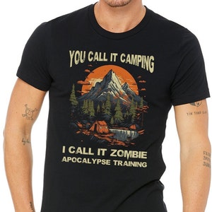 May include: Black t-shirt with a graphic of a mountain landscape and the text "You call it camping I call it zombie apocalypse training".