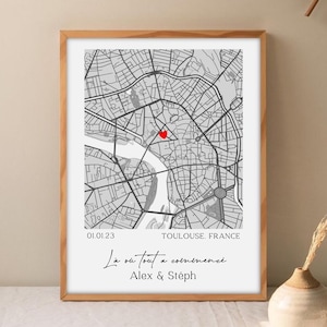 Peut inclure: Impression encadrée d'une carte de Toulouse, France, avec un cœur rouge marquant un lieu. L'impression comprend la date 01.01.23 et le texte "La où tout a commencé" avec les noms Alex & Stéph. La carte est en niveaux de gris, dans un cadre en bois.