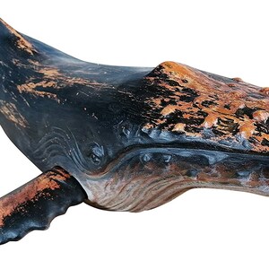 May include: A wooden whale sculpture with a distressed black and brown paint finish. The whale is carved in detail and has a realistic appearance.