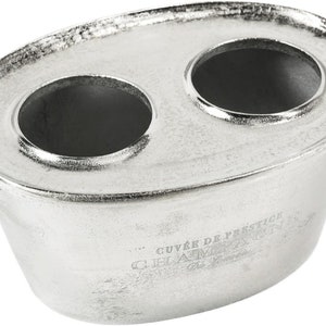 May include: Silver metal ice bucket with two round openings and a handle. The bucket has a hammered texture and the text "CUVAK DE FESTIVOL" is engraved on the side.