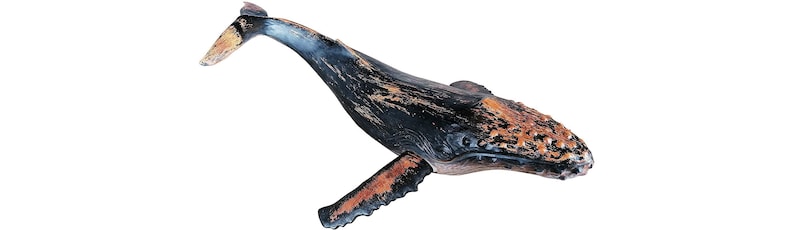 May include: A black and orange humpback whale figurine with a textured surface.