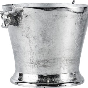 May include: Silver ice bucket with bull head handles. The bucket has a textured surface and a wide base.