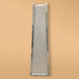 May include: A white plastic slide with a blue and gray patterned design. The slide is tall and narrow, and it is designed for children to play on.