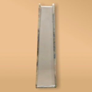 May include: A white plastic slide with a blue and green patterned design. The slide is designed for children's play.