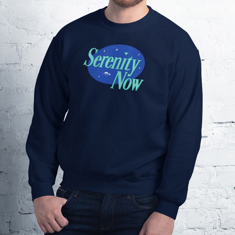 May include: A navy blue sweatshirt with a blue and green logo that says "Serenity Now" in a white circle.