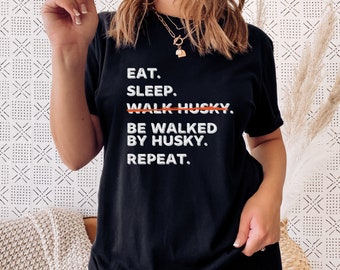 May include: Black t-shirt with white text that reads "Eat. Sleep. Walk Husky. Be Walked By Husky. Repeat."