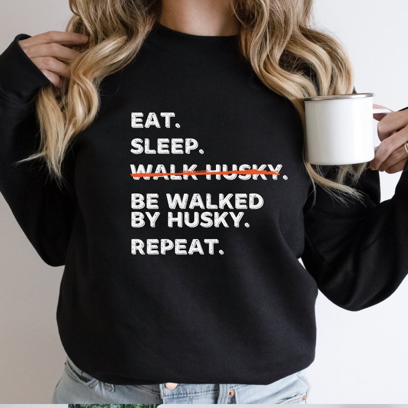May include: Black sweatshirt with white text that reads "Eat. Sleep. Walk Husky. Be Walked By Husky. Repeat."