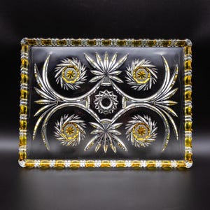 Puede incluir: Una bandeja de servir de vidrio transparente con un borde amarillo y un diseño de hojas y estrellas en vidrio cortado.