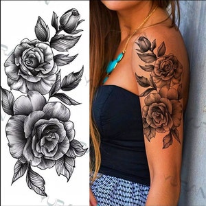 May include: Black and white temporary tattoo featuring a floral design with three roses and leaves.