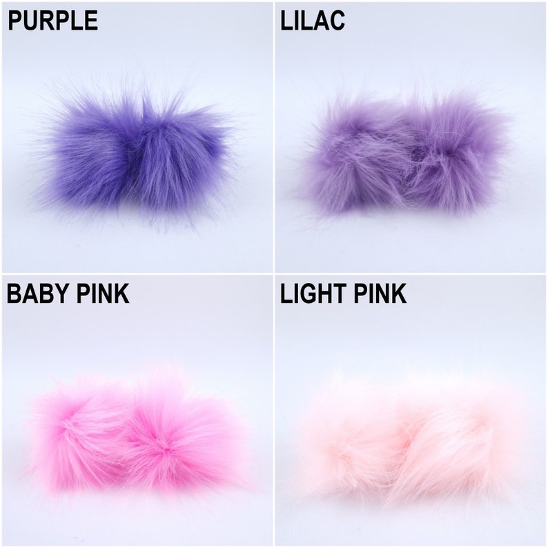 Pu&ograve; includere: Quattro pompon in pelliccia sintetica di diversi colori: viola, lilla, rosa tenue e rosa chiaro. I pompon sono disposti in una griglia.