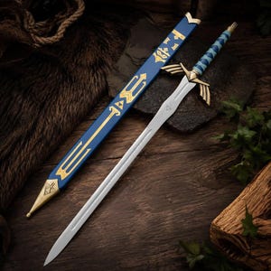 May include: A silver-toned metal sword with a blue and gold hilt featuring wing-shaped crossguards. The sword is accompanied by a matching blue scabbard decorated with gold geometric patterns and a gold-toned metal tip at the pointed end.