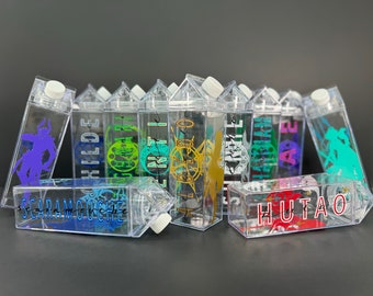 May include: A collection of clear plastic milk carton-shaped water bottles with various colorful designs and names printed on them, including "Scaraamouche" and "Hu Tao".