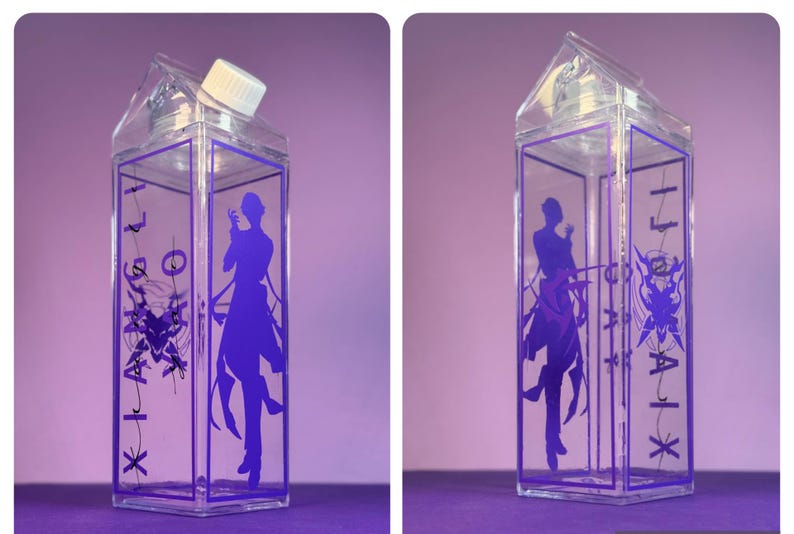 May include: Clear, rectangular water bottle with a purple design. The bottle has a white cap and a purple silhouette of a person on the front. The sides feature purple text and a graphic design. The bottle is on a purple surface.