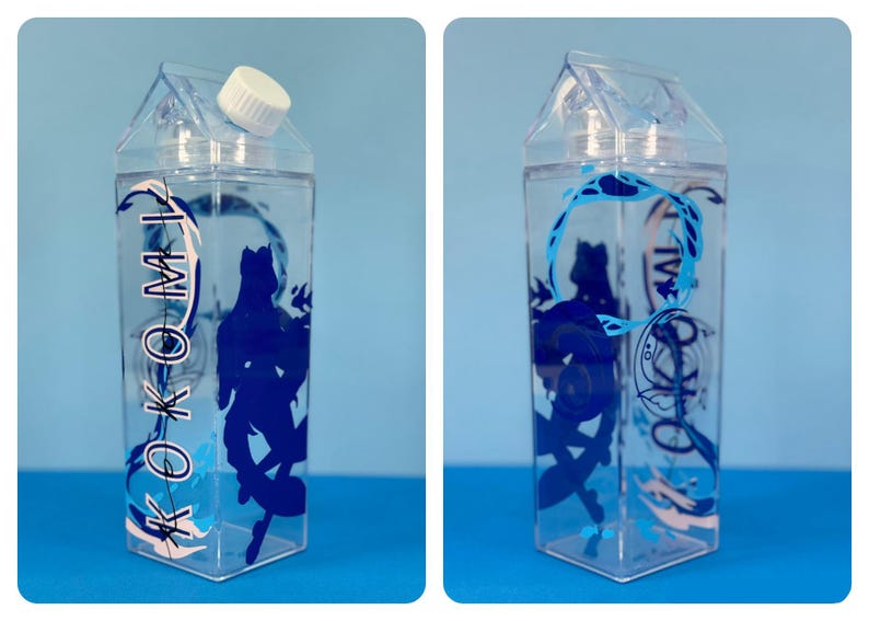 May include: Clear plastic water bottle with a white cap, shaped like a milk carton. The bottle features a blue silhouette design of a figure and the word "KOKOMI" in a stylized font. The bottle is filled with clear liquid.