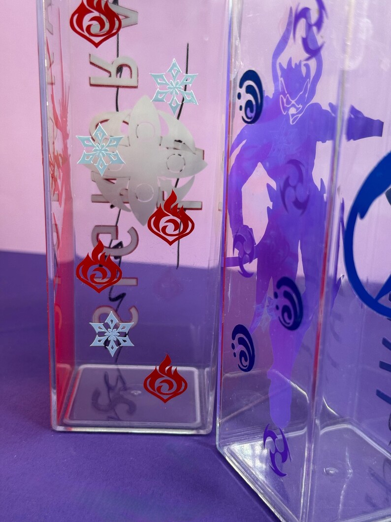 May include: Clear, rectangular water bottles with character designs. One bottle features red flame and blue snowflake graphics, while another displays a purple character silhouette. The bottles are made of clear plastic.