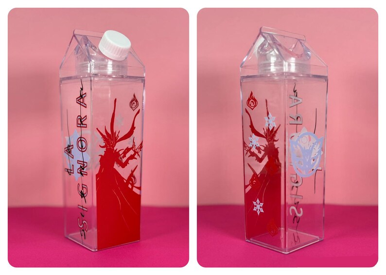 May include: Clear, rectangular water bottle with a white cap. The bottle features a red graphic of a figure with the text "LA GNORA" in black. Additional graphics include a white snowflake and a blue floral design.
