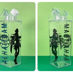 May include: Clear plastic water bottle with a white cap, shaped like a milk carton. The bottle features a black silhouette of a character and the name "ALHAAM" in teal. The design includes a teal circular graphic.