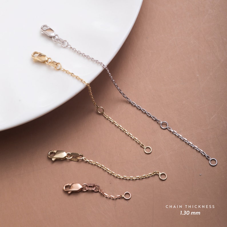 May include: Three gold chain extenders, one in silver, one in rose gold, and one in yellow gold, on a white plate. The chains are 1.30 mm thick. CHAIN THICKNESS 1.30 mm