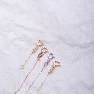 May include: Four gold chains with different clasps. The chains are in yellow gold, rose gold, and white gold.