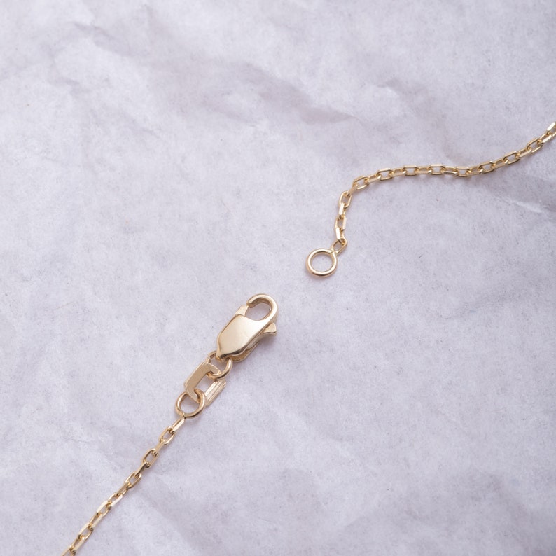 May include: A gold chain necklace with a lobster clasp fastening. The chain is made of small, round links.