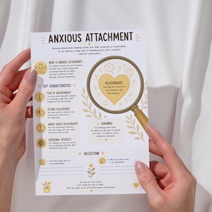 May include: A white informational sheet titled Anxious Attachment with yellow accents and illustrations. It features sections on characteristics, a magnifying glass graphic over a heart, and reflection prompts with lines for writing notes.