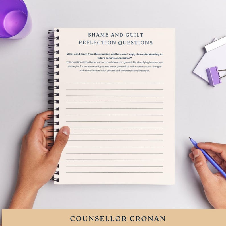 Puede incluir: Un cuaderno con una cubierta blanca y una encuadernaci&oacute;n en espiral negra. El cuaderno tiene el t&iacute;tulo "Shame and Guilt Reflection Questions" e incluye una pregunta de reflexi&oacute;n sobre c&oacute;mo aplicar las lecciones aprendidas de una situaci&oacute;n a acciones o decisiones futuras. El cuaderno tambi&eacute;n incluye el texto "COUNSELLOR CRONAN".