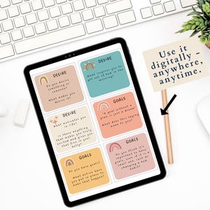 May include: A digital tablet displaying colourful cards with questions about desire and goals. The text on the cards includes phrases like "What motivates you in life?" and "Do you have goals?" The tablet is on a white surface with a pencil and a sign that says "Use it digitally - anywhere, anytime."