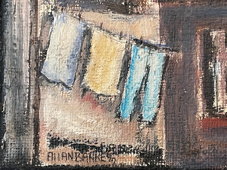 May include: A painting of a clothesline with three pieces of clothing hanging on it. The clothing is blue, yellow, and white. The painting is signed "Allan Barker" in the bottom right corner.