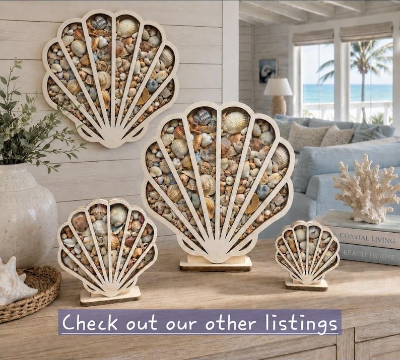Puede incluir: Una colecci&oacute;n de cuatro marcos de madera clara con forma de concha rellenos de varias conchas marinas naturales peque&ntilde;as. El conjunto incluye un marco grande de pared, uno mediano de pie y dos peque&ntilde;os de pie con el texto Check out our other listings.