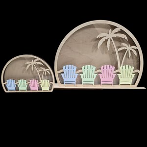 Op de afbeelding: Houten wanddecoratie met een strandsc&egrave;ne met palmbomen en vijf kleurrijke Adirondack-stoelen. De stoelen zijn in een rij op een zandstrand met een blauwe zee op de achtergrond geplaatst.