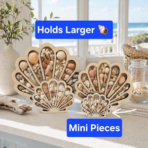 May include: Four light-colored wooden shell-shaped display cases with clear fronts, filled with various small seashells and coral fragments. The two larger cases are labeled Holds Larger, and the two smaller cases are labeled Mini Pieces.