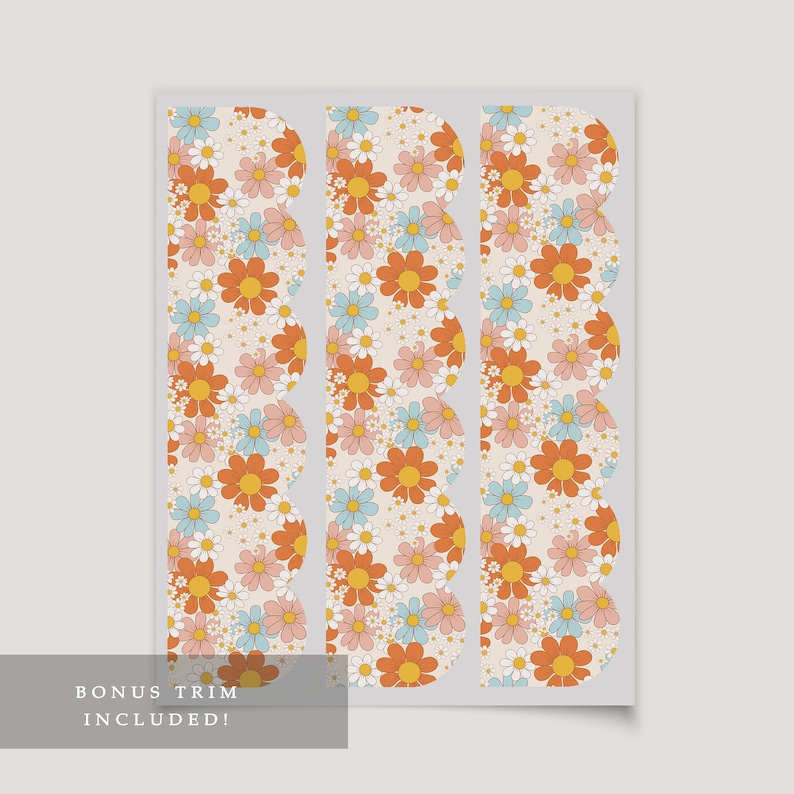 Op de afbeelding: Drie gegolfde bloemversieringen met een witte achtergrond en een patroon van oranje, roze en blauwe bloemen. De tekst "BONUS TRIM INCLUDED!" staat onderaan de afbeelding.