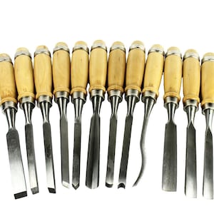 May include: A set of wood chisels with wooden handles and silver blades. The chisels are arranged in a row, showcasing various blade shapes for woodworking and carving projects. The handles are light brown, and the blades are shiny.