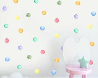 Puede incluir: Una pared blanca con pegatinas de lunares de colores. Un taburete rosa con una lámpara en forma de nube blanca y un arcoíris en el suelo.